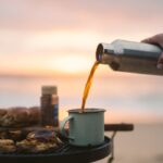 A Hand Pouring Coffee on a Cup